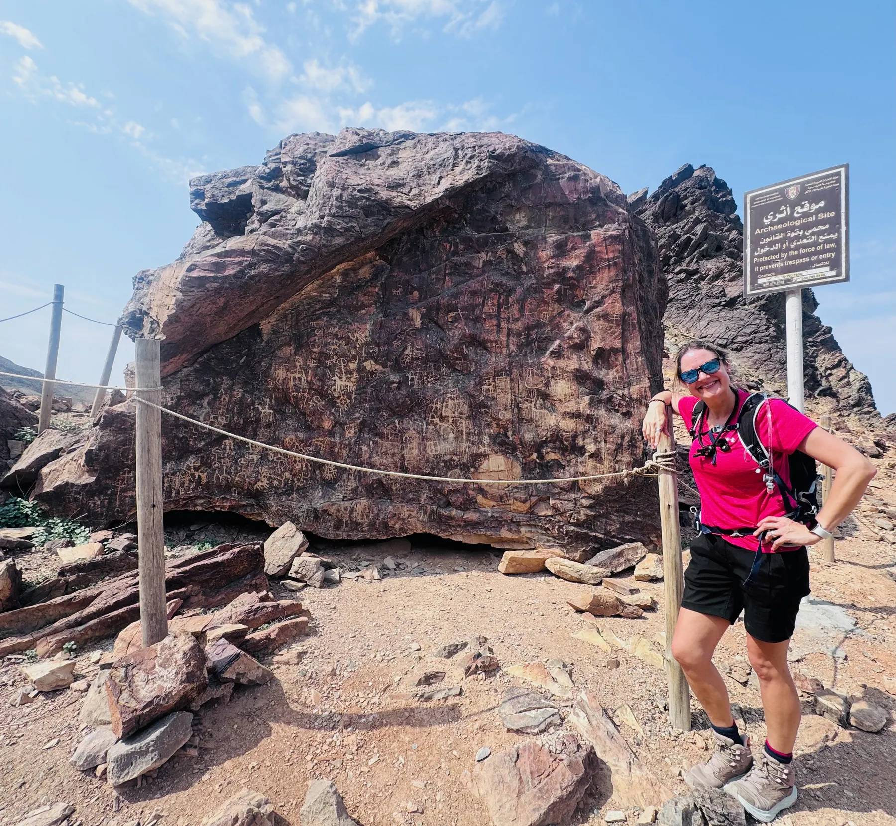 Amy beside the great carved boulder on the Hajar Mountains trail